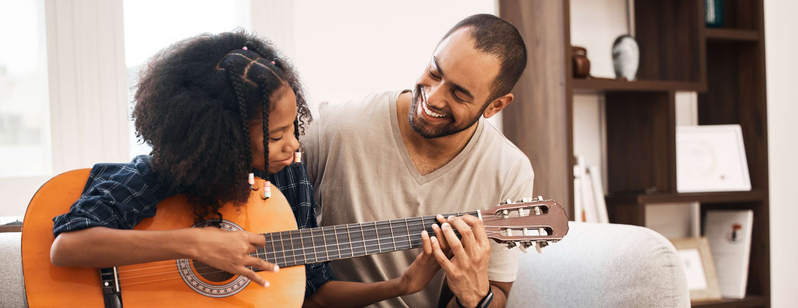 Allianz Taschengeldtabelle: Ein Vater bringt seiner Tochter das Gitarrespielen bei