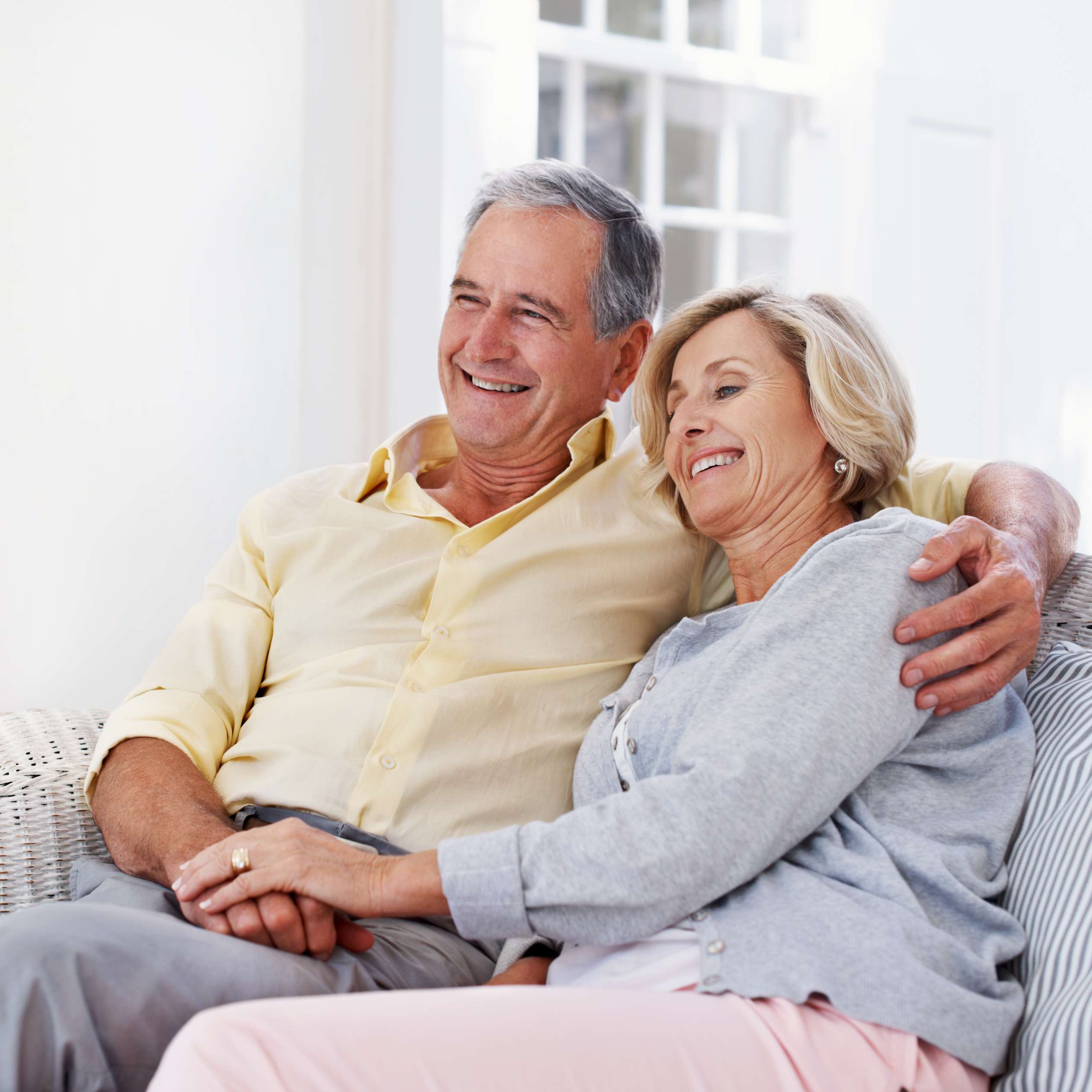  Allianz - Private Rentenversicherung: Älteres Ehepaar sitzt zufrieden auf dem Sofa