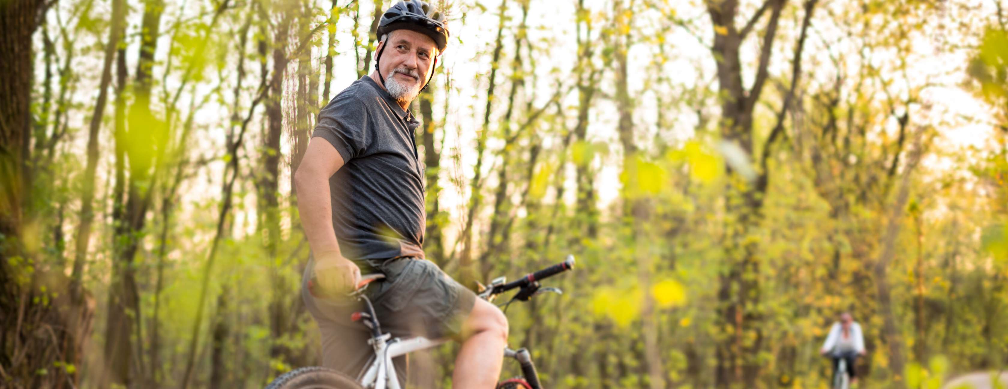 Ältere Mann fährt Mountainbike im Wald