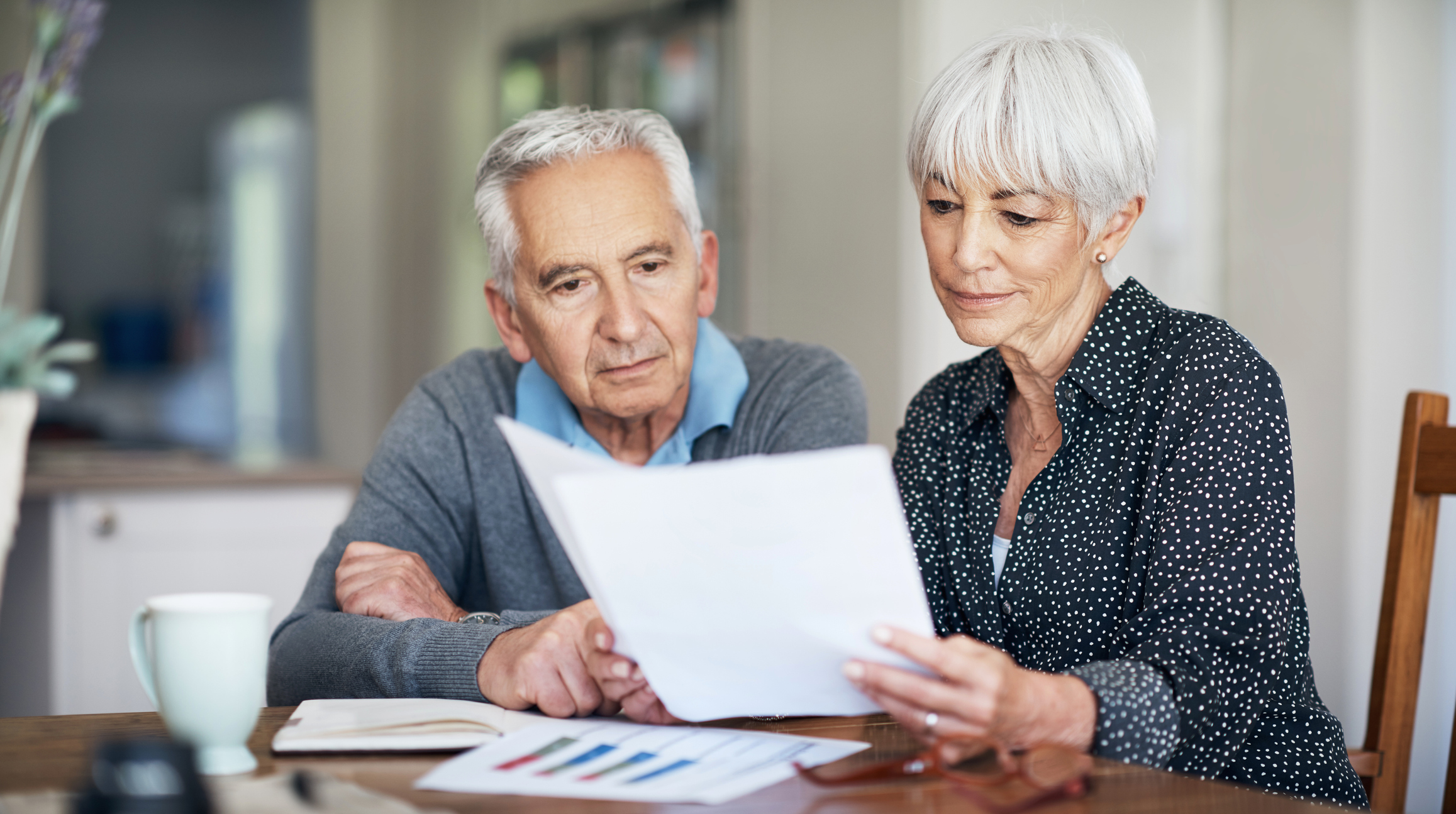 Allianz - Rentenwelt - Rente vererben: Älteres Paar schaut sich Dokumente an