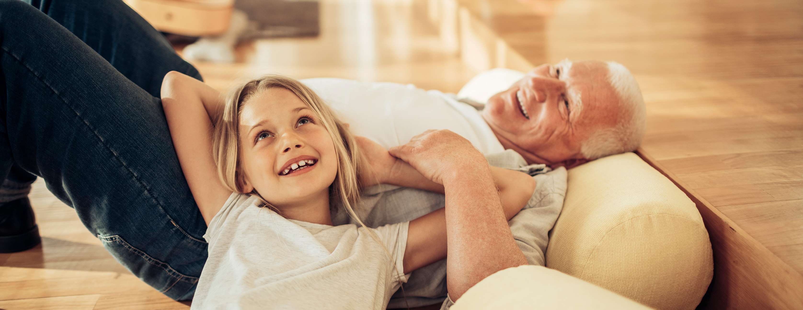 Allianz - Glücklicher Opa mit Enkelin im Wohnzimmer