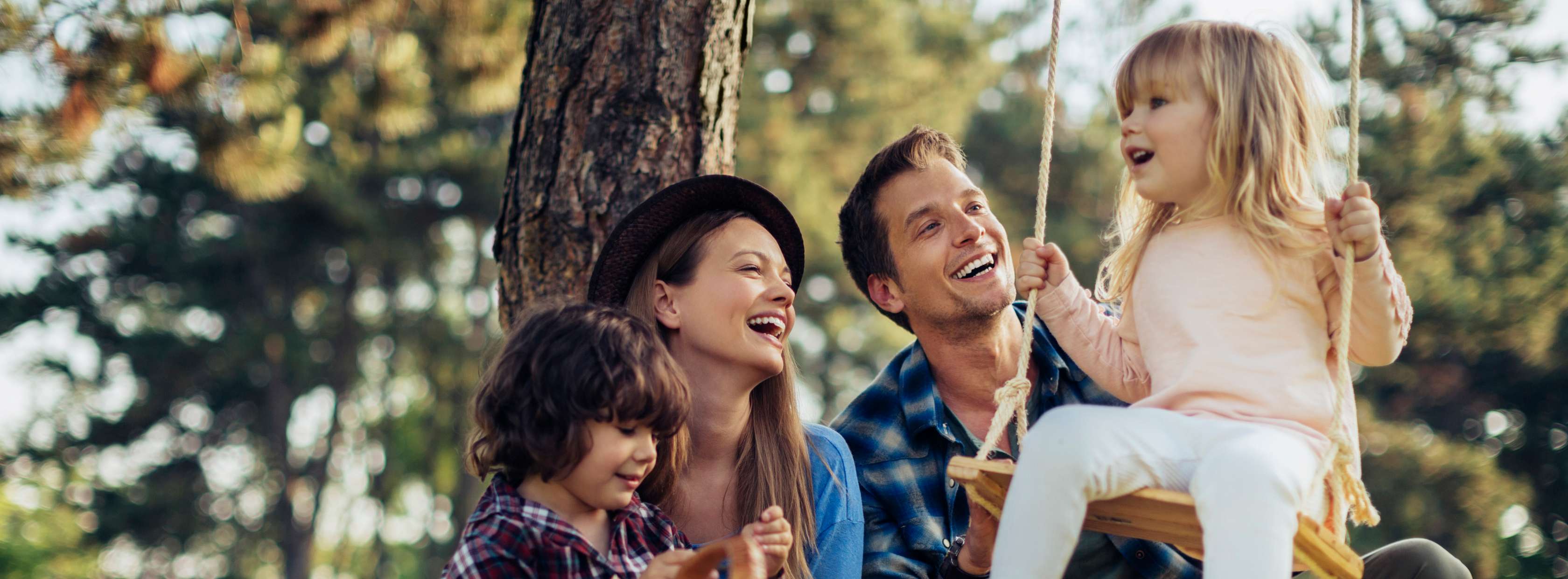 Allianz Riester Rente Förderung - Familie ist im Garten und Vater schubst die Tochter auf der Schaukel an.