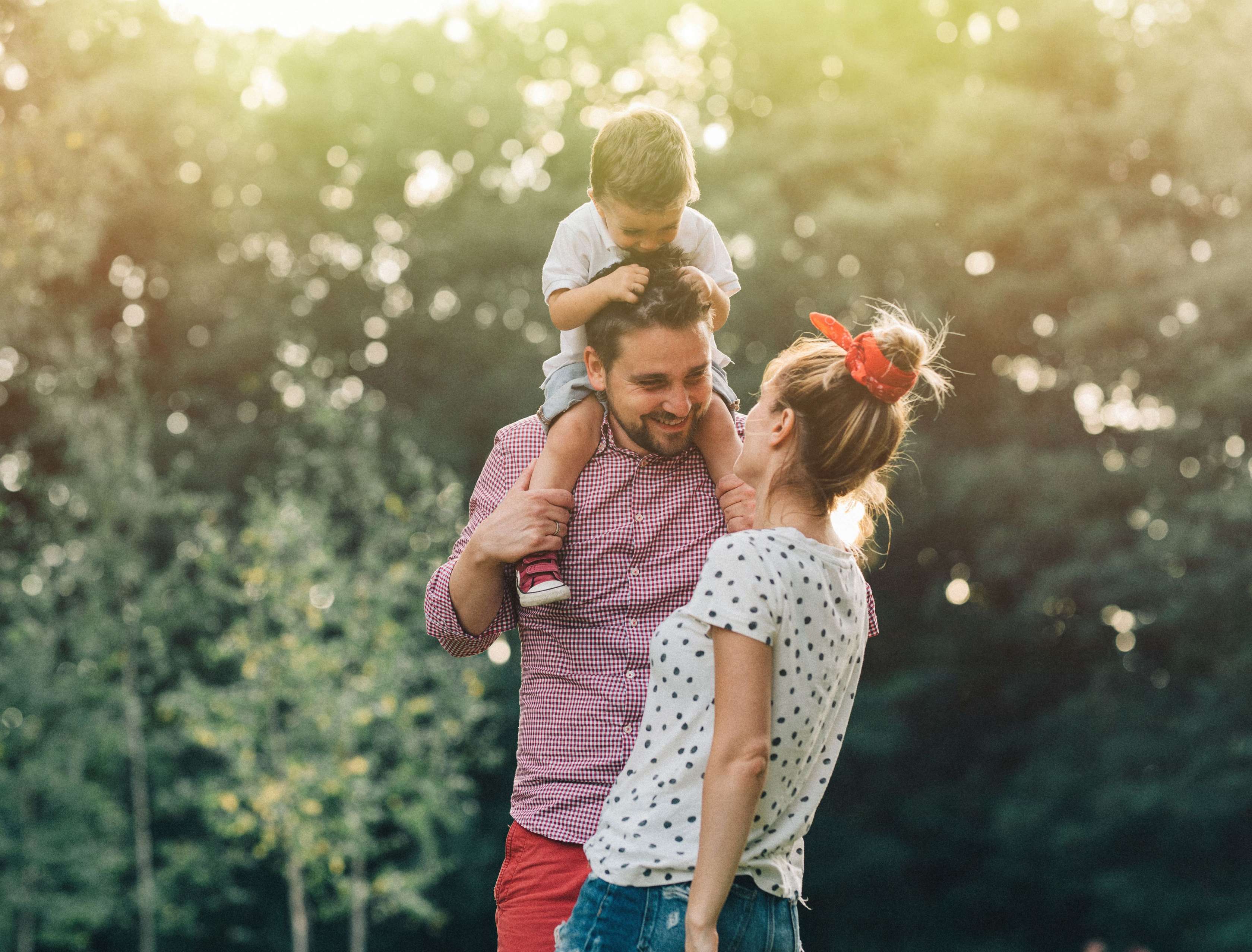 Wie die Allianz Risikolebensversicherung als finanzielle Absicherung für Familien und Kinder dient. Eine junge Familie steht im Garten und spielt.