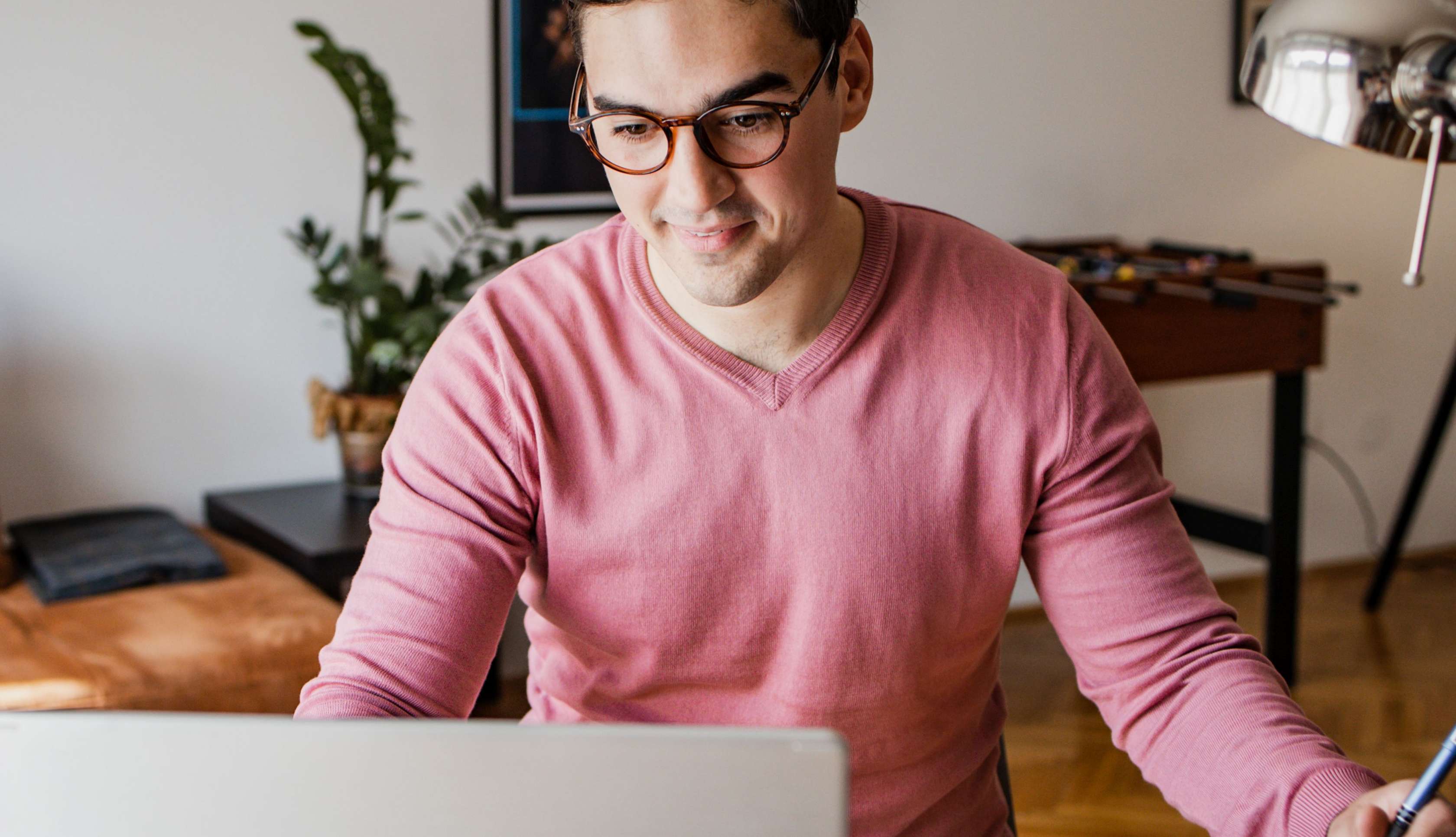 Allianz Rürup Rente StartUp - Ein Mann mit Brille sitzt an einem Schreibtisch und arbeitet am Laptop.