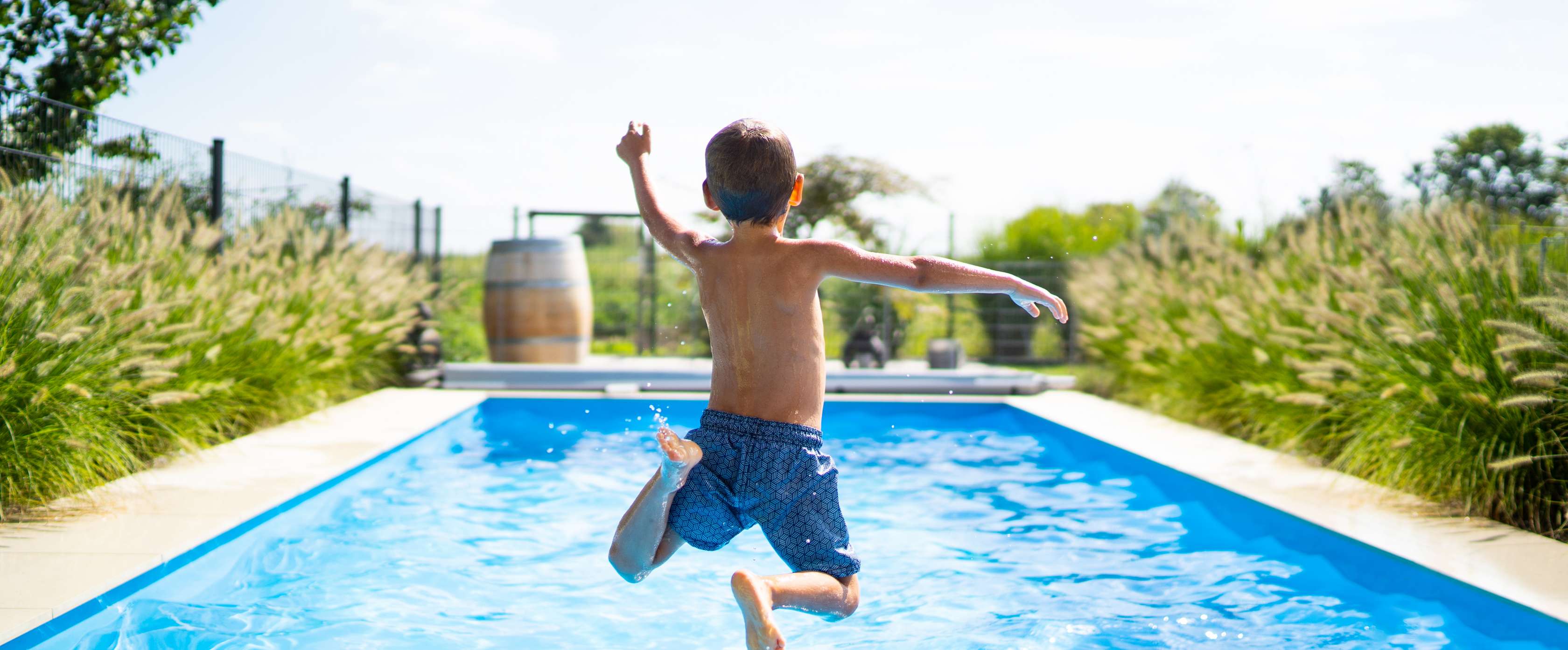 Junge springt in einen Pool.