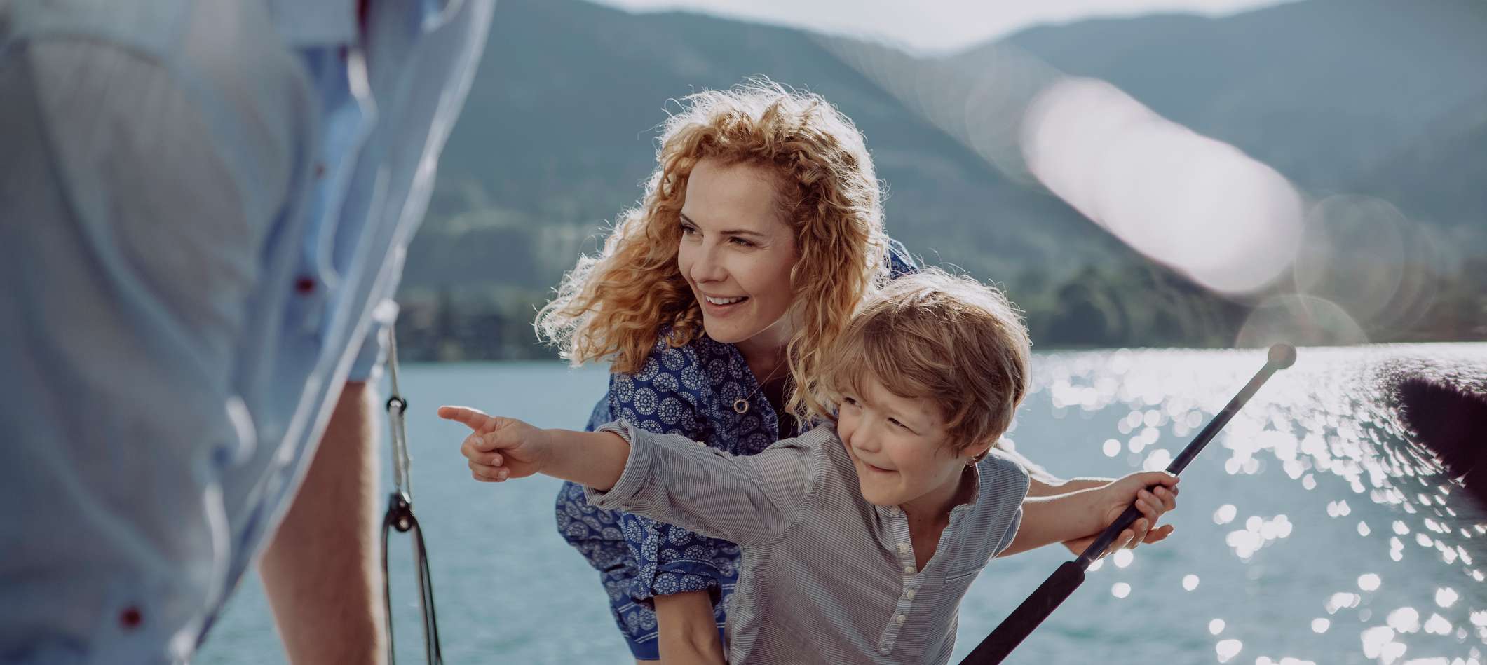 Allianz Unfallversicherung - Eine Mutter spielt mit ihrem Sohn auf einem Boot auf einem Bergsee