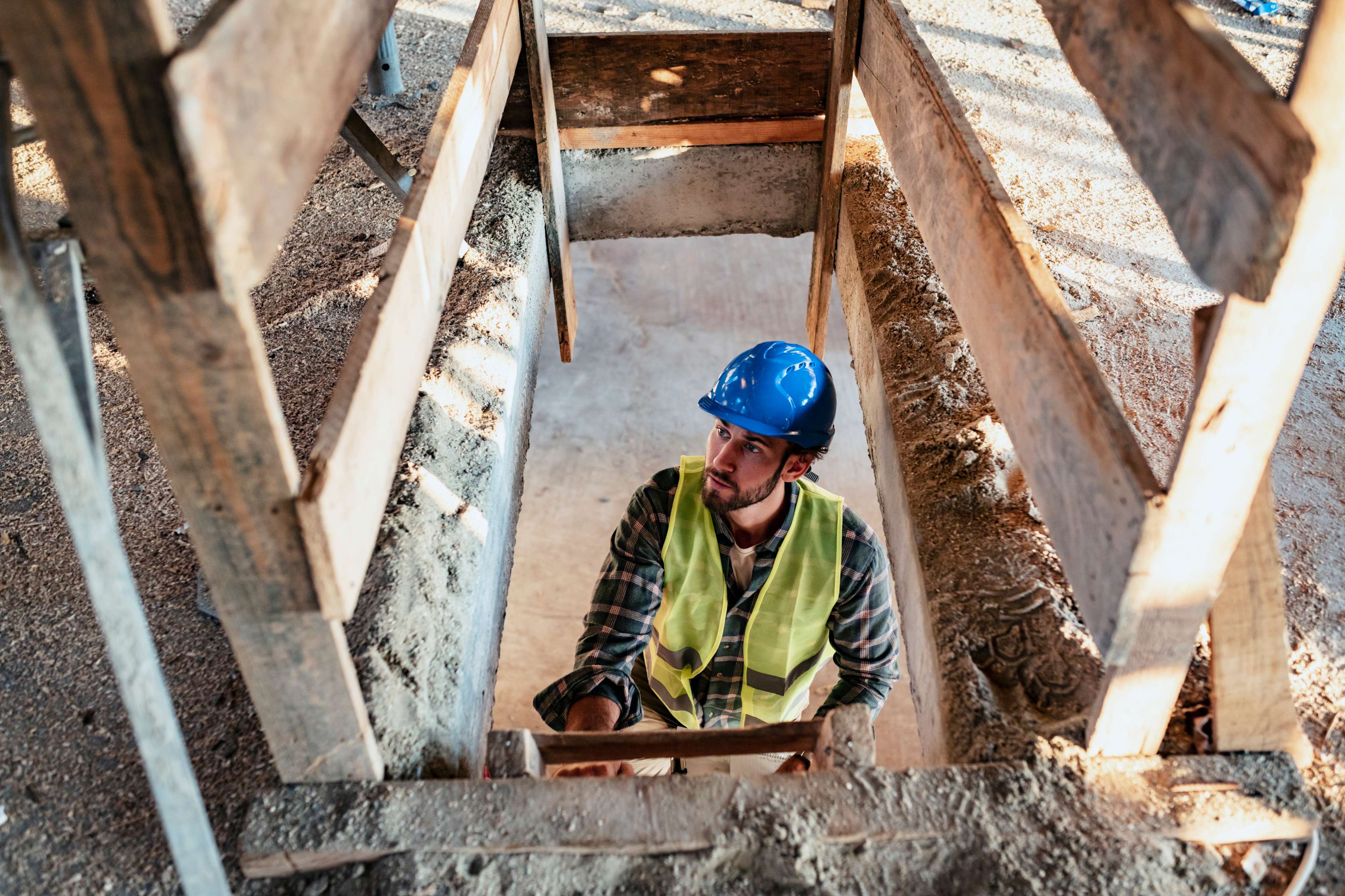 Allianz - Unfallversicherung Gefahrengruppen: Bauarbeiter klettert auf Baustelle die Leiter hoch