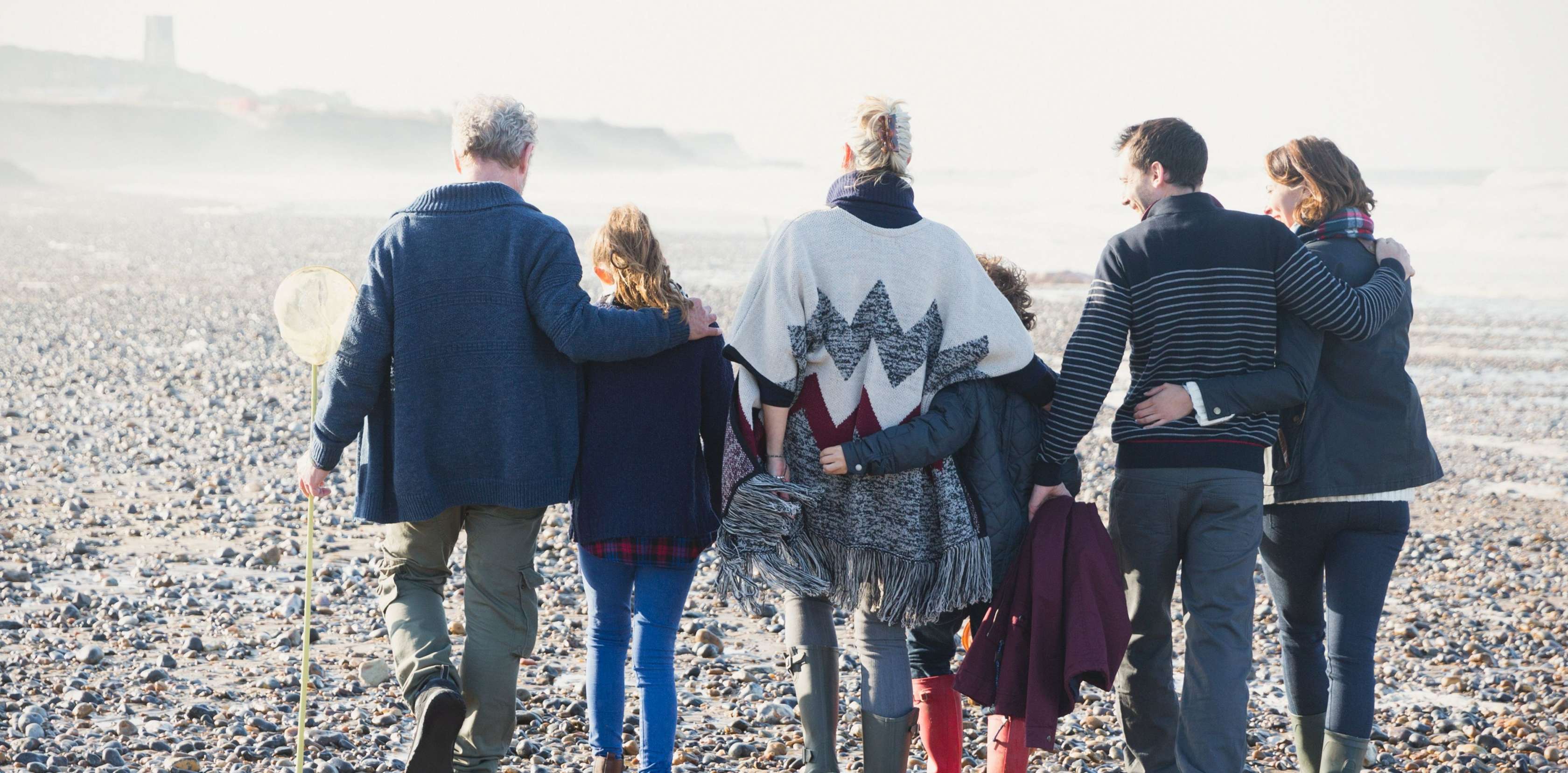 Vermögensanlagen: Eine Familie macht einen Strandspaziergang.