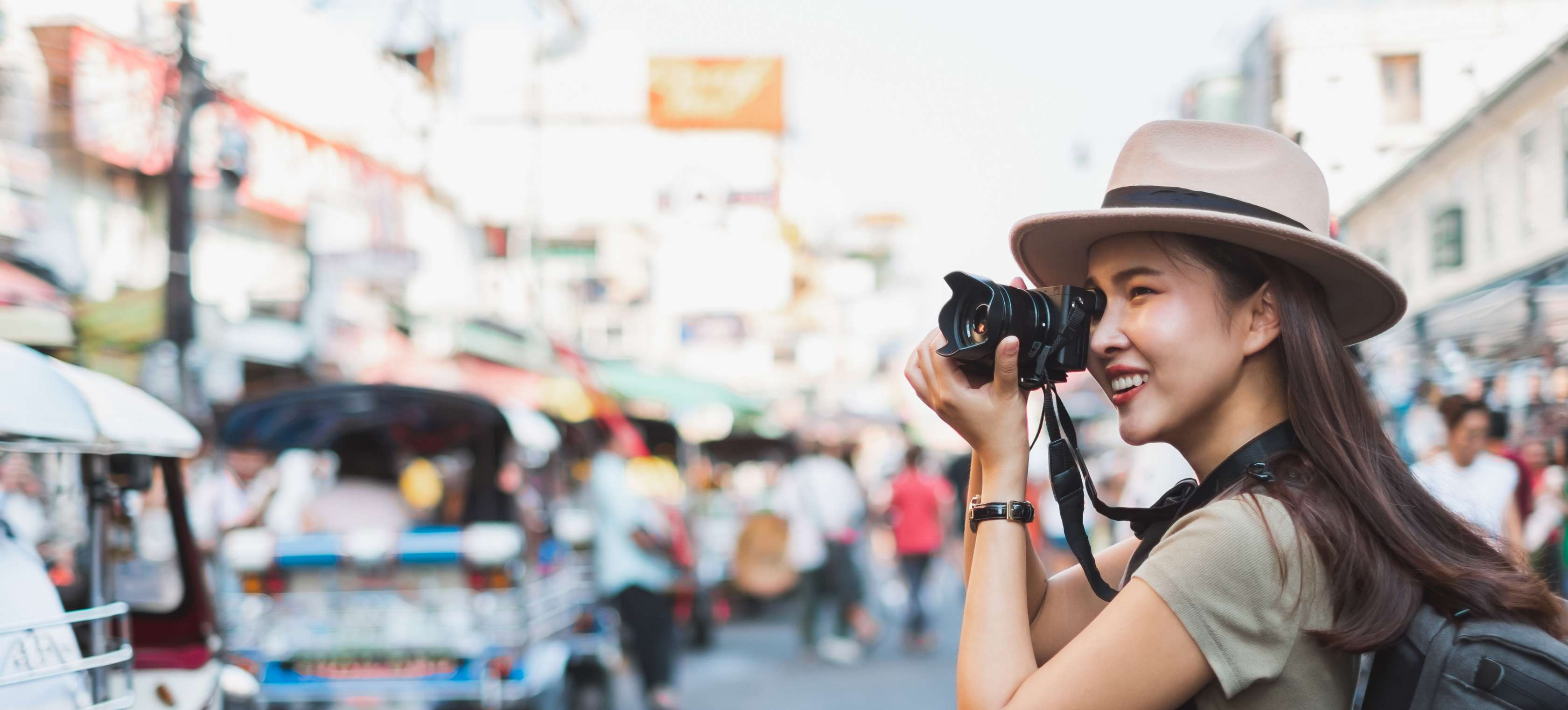 Junge Frau mit Kamera in asiatischer Stadt